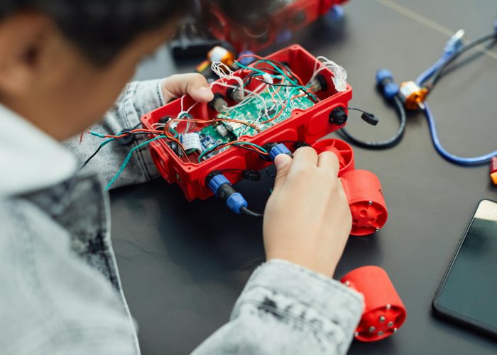 pexels-photo-7869034-7869034 A child actively assembling a robotics project with electronic components, showcasing technology education.